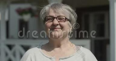 在阳光明媚的日子里，在<strong>养老院</strong>拍摄的带有眼镜的微笑老妇人看镜头